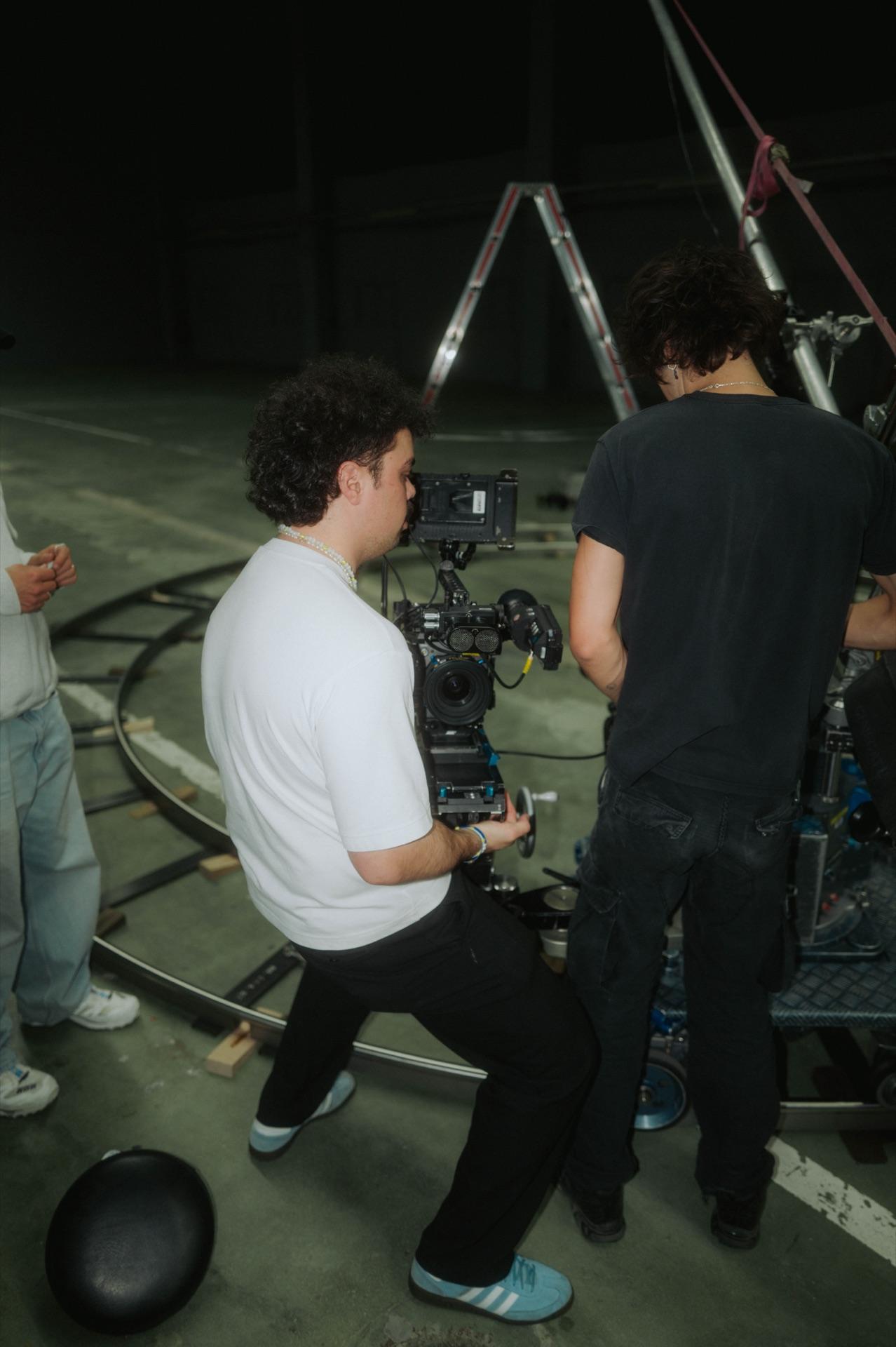 Kameramann fährt die ARRI auf dem Dolly, ein Crew-Mitglied hält gegen