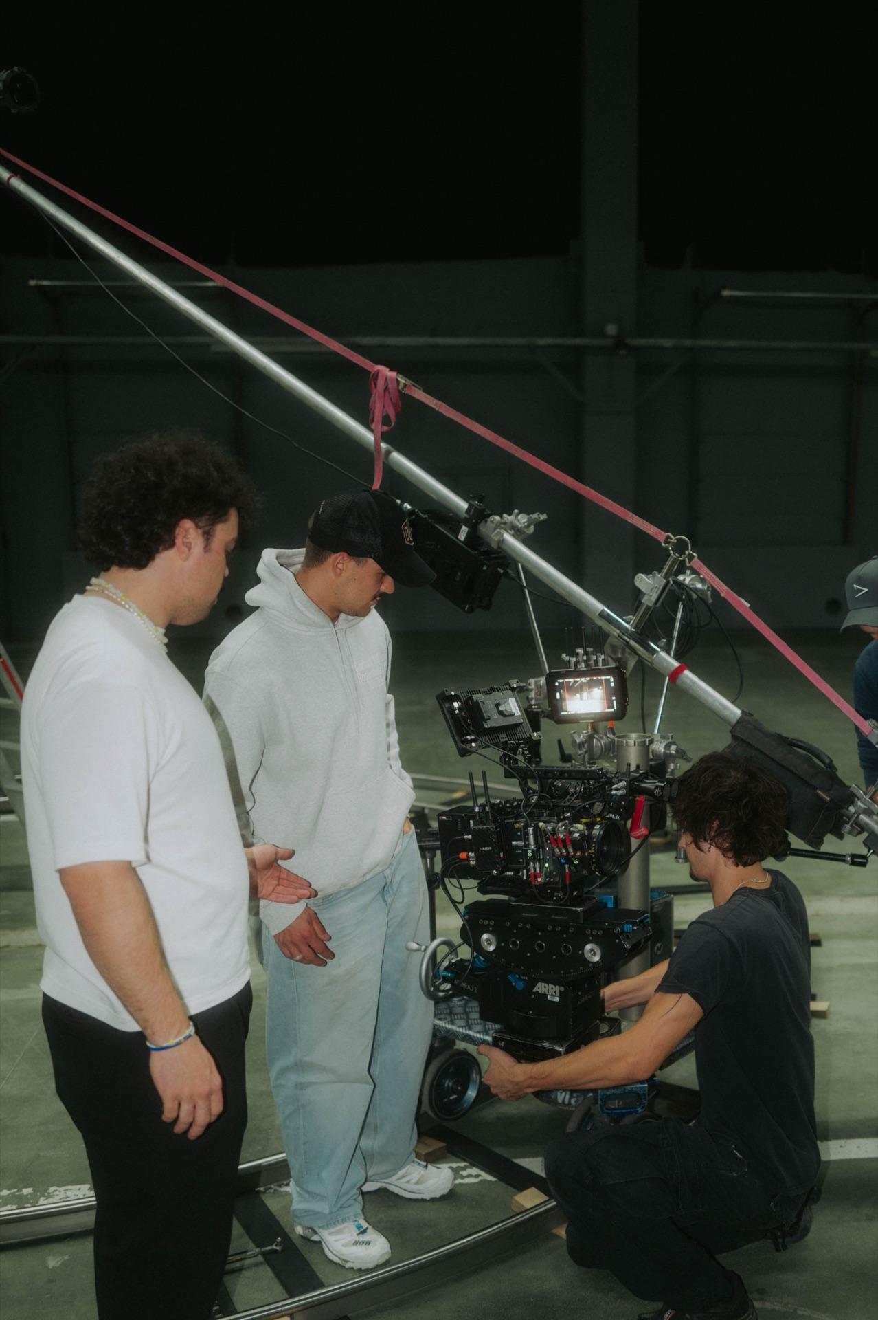 Die Crew schaut zu, während die Kamera auf dem Dolly eingestellt wird