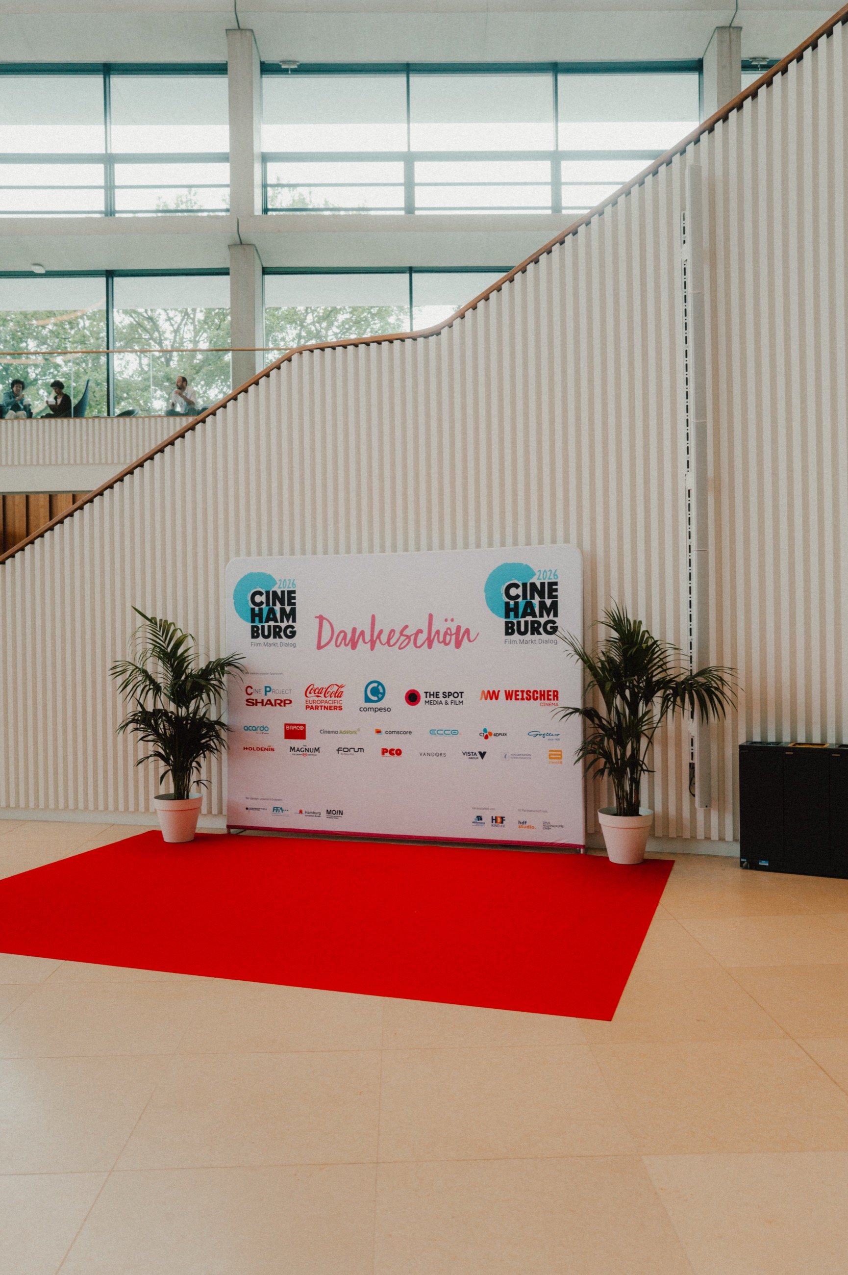 Fotowand der CineHamburg mit dem Schriftzug Dankeschön und den Logos der Partner, davor ein roter Teppich