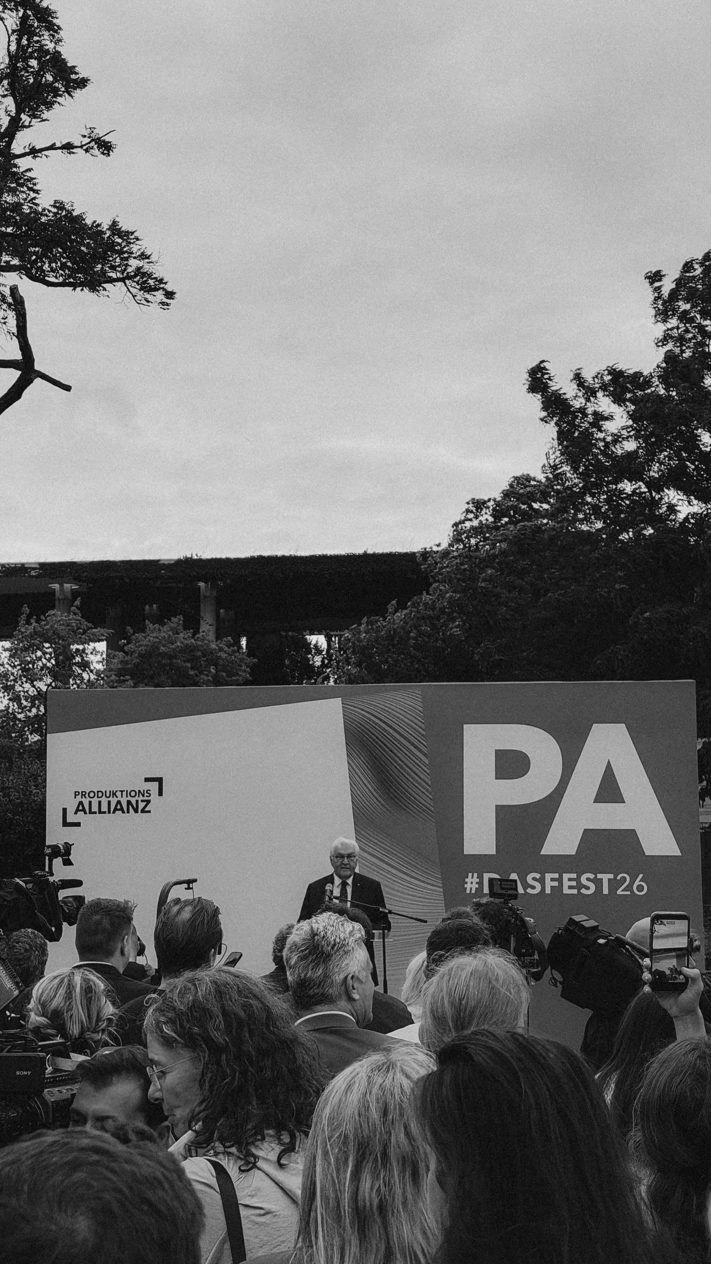 Rede am Pult vor der Bühnenwand mit dem Logo der Produktionsallianz und dem Hashtag „#DASFEST26“, davor Publikum und aufgebaute Fernsehkameras